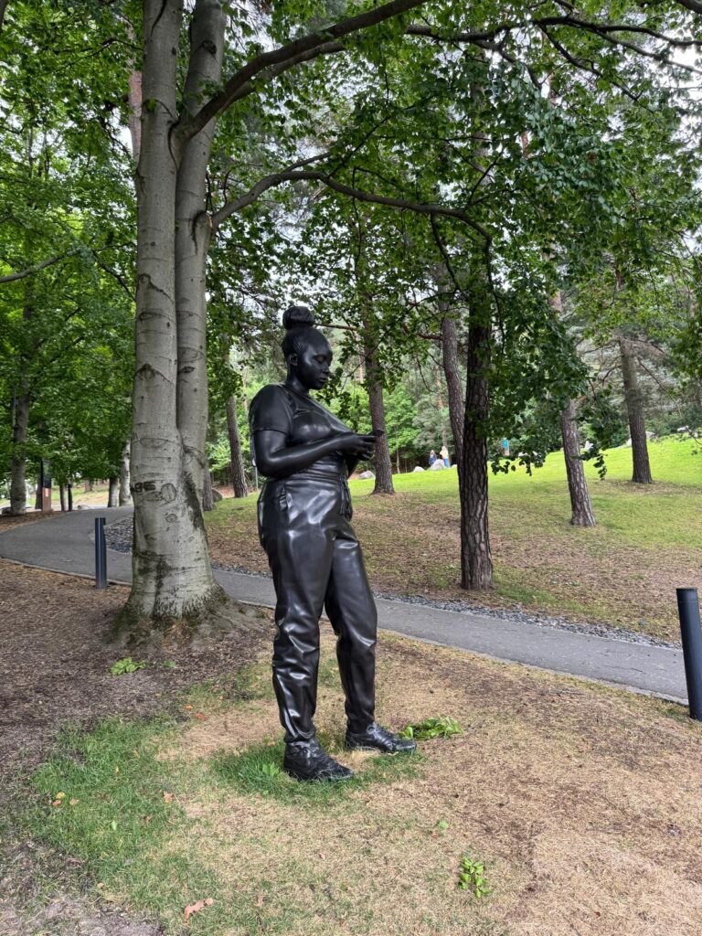 "Beelden en sculpturen verspreid over de groene paden van Ekebergparken in Oslo, met een prachtig uitzicht op de stad en de Oslofjord."