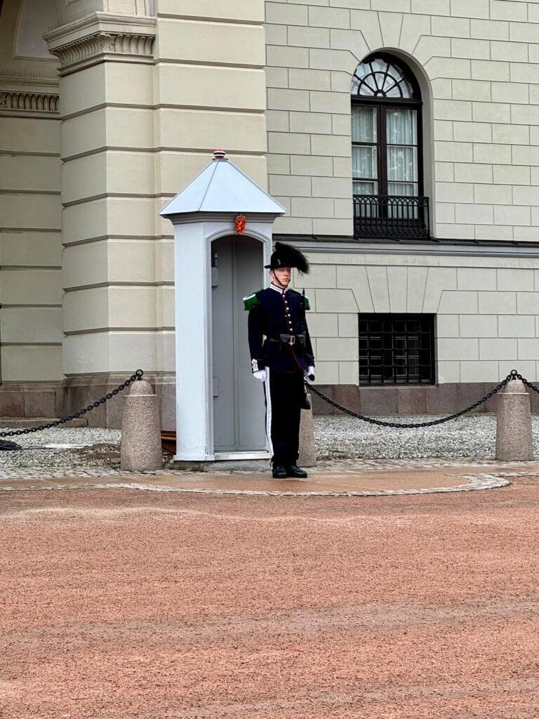 "Het indrukwekkende Koninklijk Paleis van Oslo, omgeven door mooie tuinen en het iconische standbeeld van de koning aan de voorzijde."