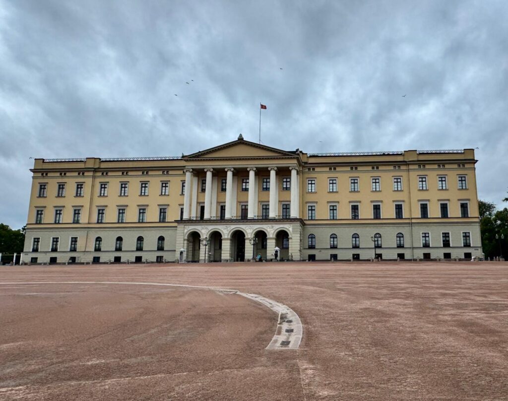 "Het Koninklijk Paleis in Oslo, een neoclassicistisch gebouw met een prachtige gevel en groene tuinen, gelegen aan het einde van Karl Johans Gate."