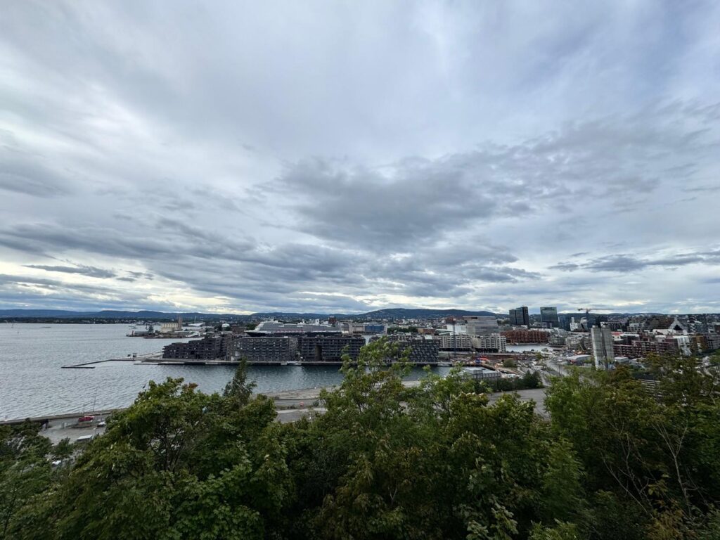 "Wandelaar in Ekebergparken in Oslo, langs beelden van beroemde kunstenaars en uitzicht op de skyline van Oslo."