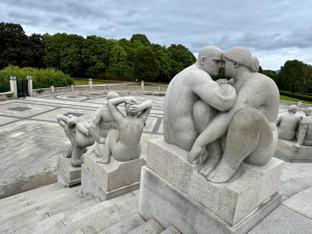 "Prachtige sculpturen van mensen in verschillende levensfasen in Vigelandsparken, Oslo, omringd door groene tuinen en wandelpaden."